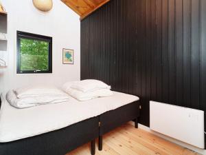 uma cama num quarto com uma parede preta em Holiday home Jægerspris XVII em Jægerspris