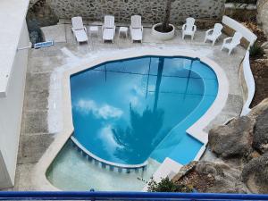 an overhead view of a swimming pool with chairs and a palm tree at Secretos del Sol Acapulco villas a 5 minutosdel mar in Acapulco