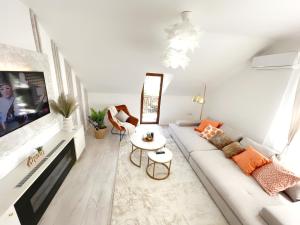 STUDIO POIENII - a cozy stay 5 min away from the center في بيستريتسا: غرفة معيشة بيضاء مع أريكة وتلفزيون