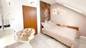 1 dormitorio con 1 cama y 1 silla en STUDIO POIENII - a cozy stay 5 min away from the center, en Bistriţa