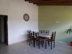 Tierra del Sol y el Vino في سان رافاييل: طاولة طعام مع كراسي وساعة على الحائط