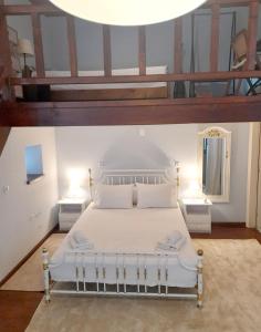 a bedroom with a white bed with two night stands at ZOE in Keramoto