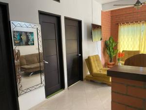 un soggiorno con 2 porte nere e una sedia di Apartamento acorde para una estadía tranquila. a Apartadó