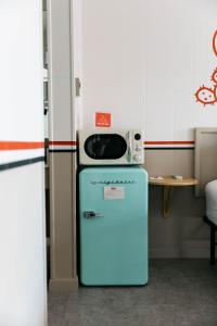 a microwave on top of a blue refrigerator at Mesa Verde Motel in Mancos