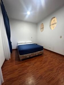 une chambre avec un lit et un parquet dans l'établissement Hotel Artistico, à Bogotá
