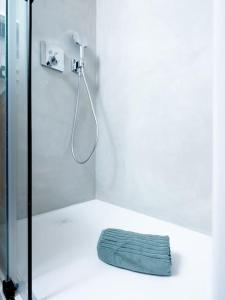 een badkamer met een douche en een blauwe handdoek op de vloer bij Small but WOW! Studio with pool @ the central lake in Crans-Montana