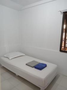 a white bed with a keyboard on top of it at Homestay dekat Darussalam & Ulee Kareng in Lamnyong