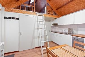 een ladder in een keuken met witte kasten bij House on the river in Goudswaard