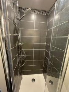 W łazience znajduje się prysznic ze szklanymi drzwiami. w obiekcie Villa Marylou w mieście Bernières-sur-Mer