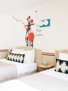 2 camas en una habitación con un cartel en la pared en Mesa Verde Motel, en Mancos