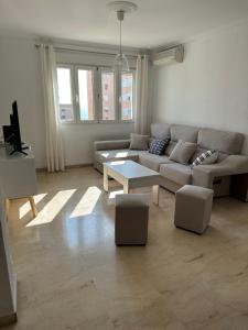 ein Wohnzimmer mit einem Sofa und einem Tisch in der Unterkunft Apartamento Vista-Beach in Cádiz
