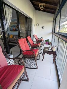 een balkon met schommelstoelen en een tafel bij Apartamento a 5 min de la playa in San Felipe de Puerto Plata