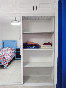 1 dormitorio con armario con estanterías blancas en Apartamento a 5 min de la playa, en San Felipe de Puerto Plata