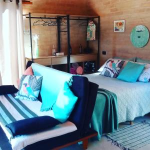 a bedroom with a bed and a couch with pillows at Sonho na Serra Chalé 2 in Gonçalves