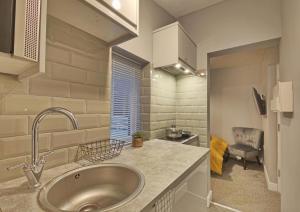 a kitchen with a sink and a chair in a room at Cosy Holiday Studio in Hazel Grove - Self Catering Apartment 1 in Hazel Grove