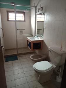 y baño con aseo, lavabo y ducha. en Casa pura vida en General Roca