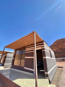 un pequeño edificio con un poste delante en WADi RUM NOOR CAMP, en Wadi Rum