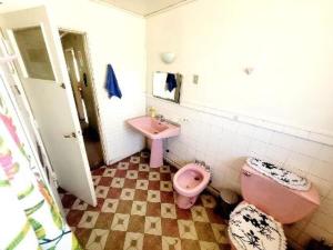baño con aseo rosa y lavamanos en Eliodoro Yañez Casa o chalet, en Valdivia