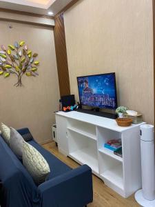 un salon avec une télévision sur un bureau blanc dans l'établissement Twenty-Nine Cats - SMDC Cheer Residences Marilao, à Marilao
