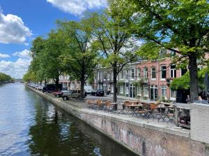 a canal with tables and chairs next to a river at Canal View Stay Amsterdam in Amsterdam