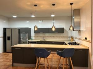a kitchen with two chairs and a counter and a refrigerator at Bakio Beach House in Bakio +20 photos