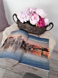 un libro su un tavolo con un vaso di fiori di MarlA1 a Vodice