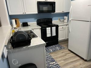 a kitchen with a white refrigerator and a sink at Serene Getaway with Fast Wi-Fi Deck Fire Pit Roku in Montgomery