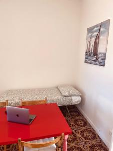 um quarto com uma mesa vermelha e um computador portátil em Jama's Panoramic Estate Modica em Modica