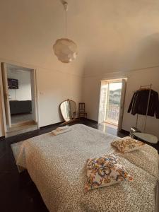 een slaapkamer met een bed met 2 kussens erop bij Jama's Panoramic Estate Modica in Modica