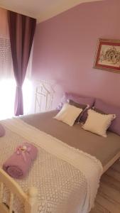 una camera da letto con un grande letto con pareti viola di MarlA1 a Vodice