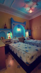 a bedroom with a bed with a blue head board at Taddart Aglou in Aglou