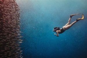 a woman is swimming in the water at The Backyard Inn in Moalboal