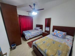 a bedroom with two beds and a ceiling fan at Babel Ain Sokhna in Ain Sokhna