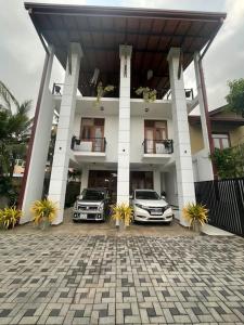two cars parked in front of a building at Aradhana-4 Bedroom Luxury Holiday Home in Kandana
