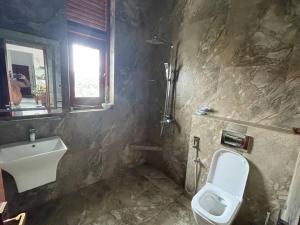 a bathroom with a sink and a toilet and a window at Aradhana-4 Bedroom Luxury Holiday Home in Kandana