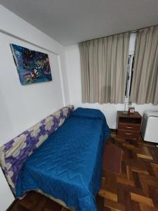 a bedroom with a bed with a blue blanket at Departamento amoblado nueva Córdoba in Córdoba