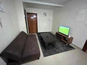 een woonkamer met een bank en een flatscreen-tv bij Residence Mly youssef appart in Safi