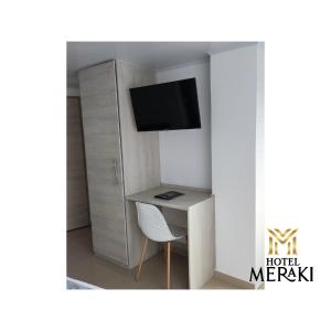 een kleine kamer met een bureau en een televisie bij Hotel Meraki Popayán in Popayan
