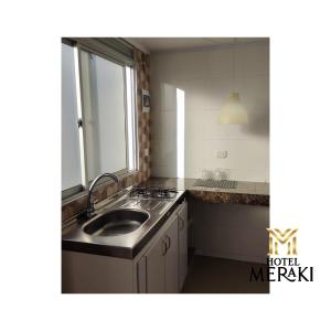 a kitchen with a sink and a counter top at Hotel Meraki Popayán in Popayan