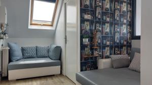 un salon avec un canapé et un mur de photos dans l'établissement LES COQUILLAGES, 2 salles de bain, 2 chambres, à Berck-sur-Mer