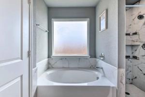 a bathroom with a bath tub and a window at Modern Home near Downtown Dallas in Lancaster