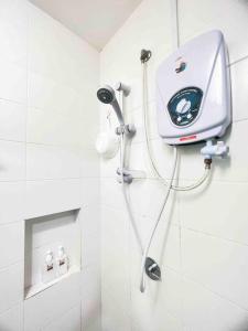 een douche in een badkamer met een machine aan de muur bij NEW Cozy Studio - Trefoil Setia Alam in Shah Alam