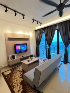 een woonkamer met een bank en een flatscreen-tv bij NEW Cozy Studio - Trefoil Setia Alam in Shah Alam