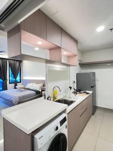 een keuken met een wastafel en een wasmachine bij NEW Cozy Studio - Trefoil Setia Alam in Shah Alam