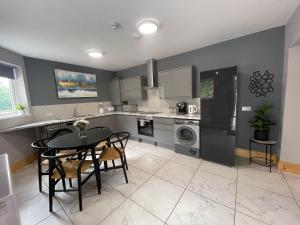 a kitchen with a table and a dining room at West Midlands-2 Double Bed Room Apartment in Dudley