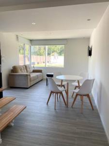 een woonkamer met een tafel en stoelen en een bank bij Casa para 4 personas en vista24uy, Bella Vista, Maldonado in Bella Vista