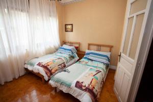 two beds sitting next to each other in a bedroom at Sea Breeze and beautiful views! in Muros de Nalón