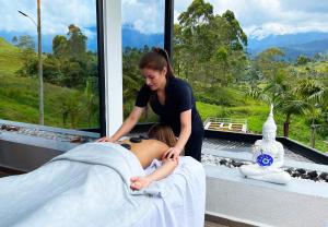 une femme qui donne un massage à une femme dans l'établissement Aguas Claras Luxury Hospedaje, à Filandia