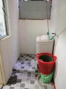 um pequeno quarto com um balde no chão em Sis Homestay Wakaf Che Yeh, Kota Bharu em Kota Bharu