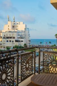 un balcon avec un bâtiment et un parking dans l'établissement Enjoy Your Vacation Here, Close to The Beach, Only 1 minute Walk!!, à Martil